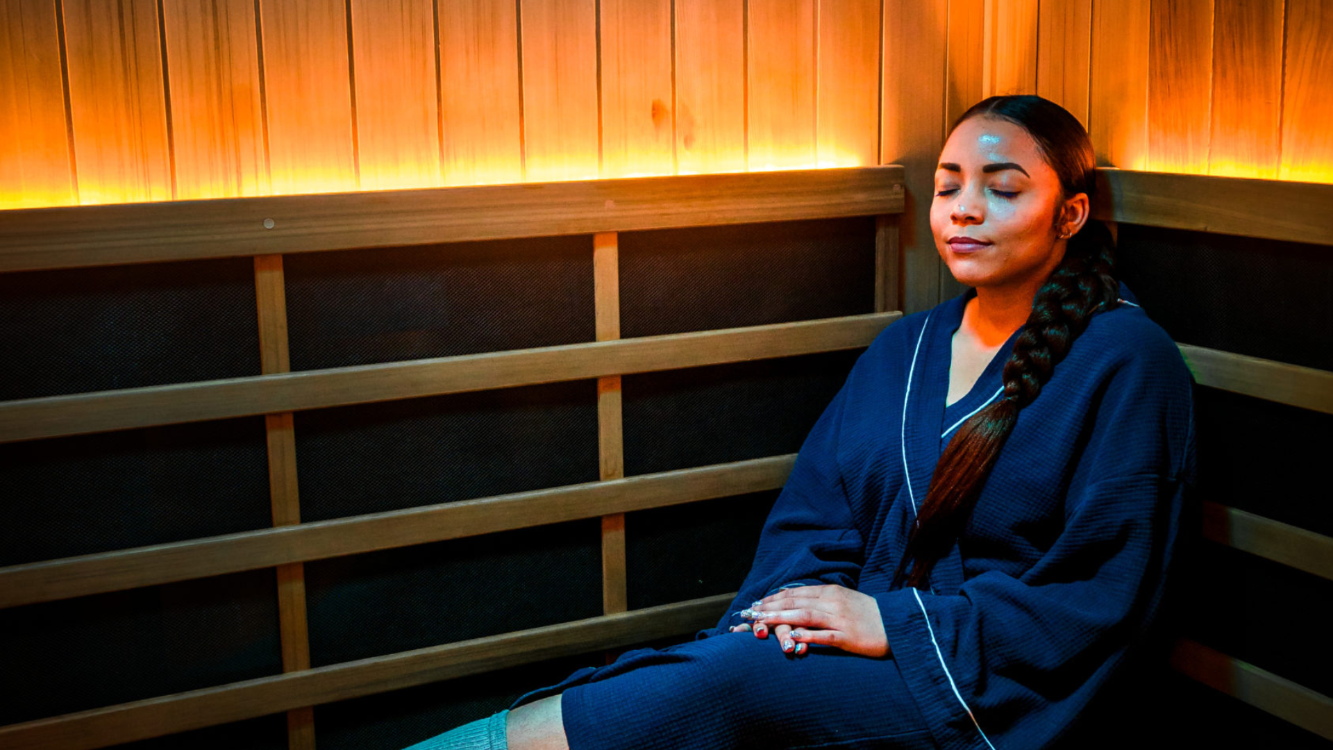 Woman relaxing in infrared sauna with therapeutic lights